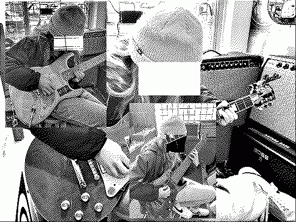 Person playing guitars in a shop.