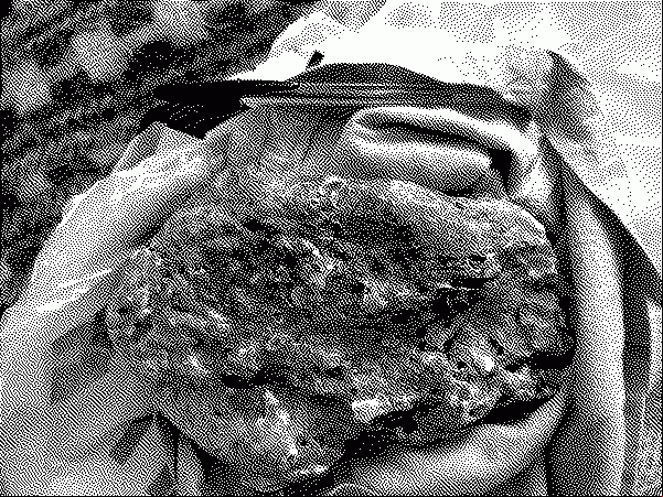 A possible chunk of ambergris on top of a bag on top of a poncho, with a pen for scale
